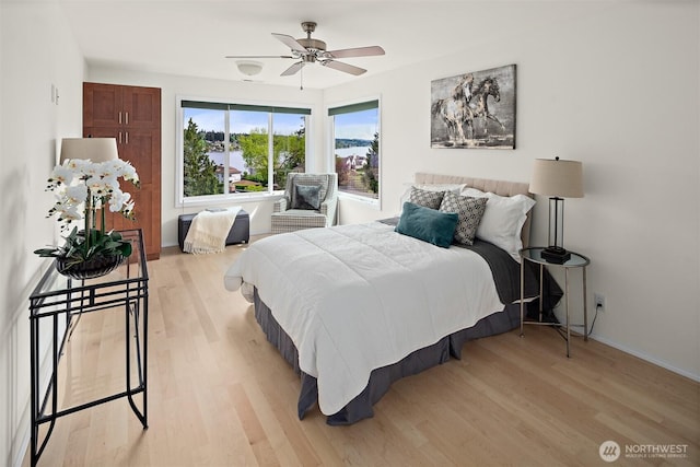 bedroom with light wood-style floors, baseboards, and ceiling fan