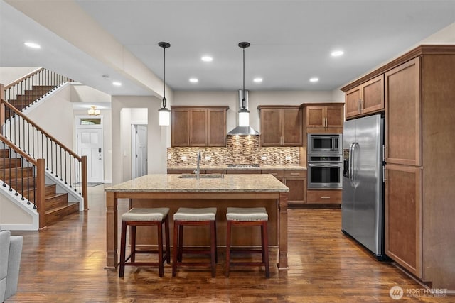 3530 128th St SE, Everett, WA 98208 - kitchen featuring stainless steel appliances, a sink, wall chimney exhaust hood, tasteful backsplash, and dark wood-style flooring