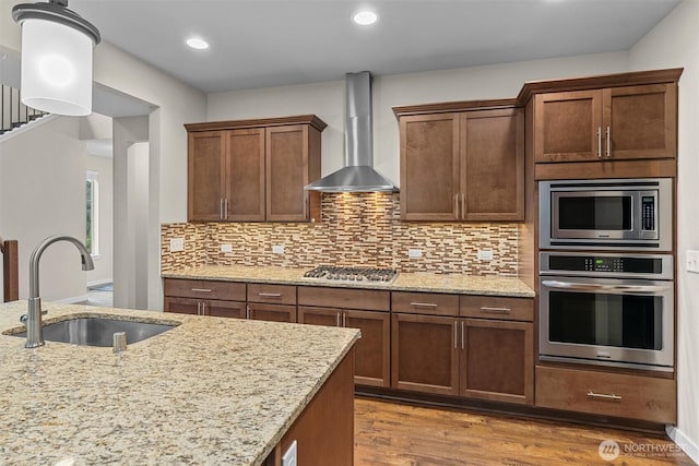 3530 128th St SE, Everett, WA 98208 - kitchen with stainless steel appliances, wall chimney exhaust hood, a sink, wood finished floors, and tasteful backsplash