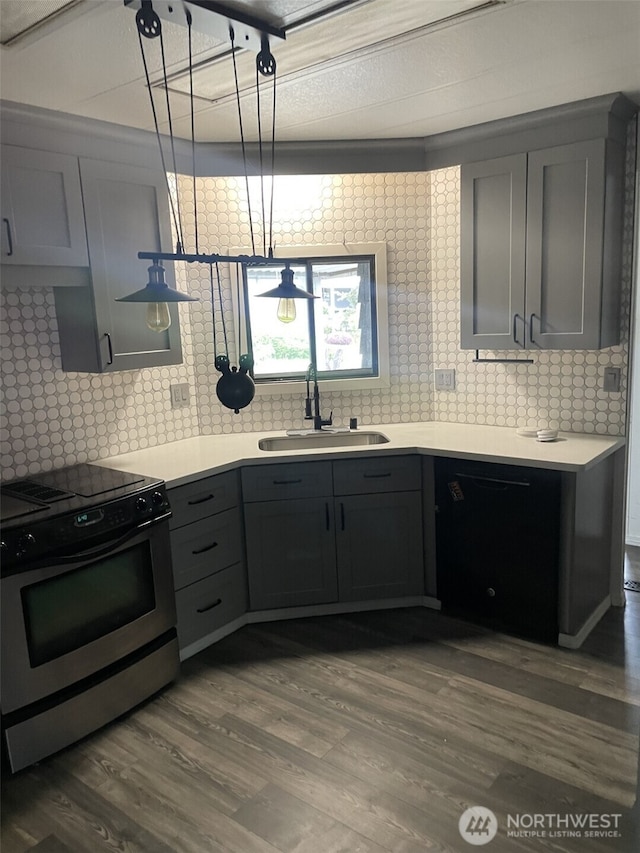 kitchen featuring dark wood-style floors, gray cabinets, a sink, backsplash, and stainless steel electric range oven