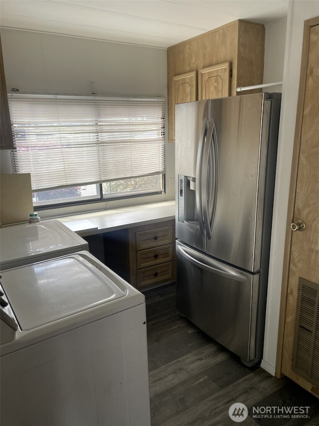 kitchen with visible vents, dark wood-style flooring, washing machine and dryer, stainless steel refrigerator with ice dispenser, and light countertops