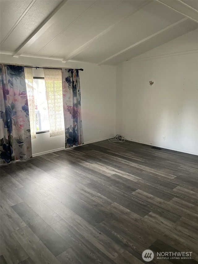 empty room featuring dark wood finished floors and lofted ceiling with beams