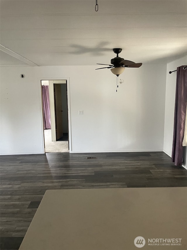 empty room featuring baseboards, ceiling fan, and wood finished floors