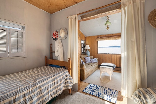 bedroom featuring wooden walls and carpet