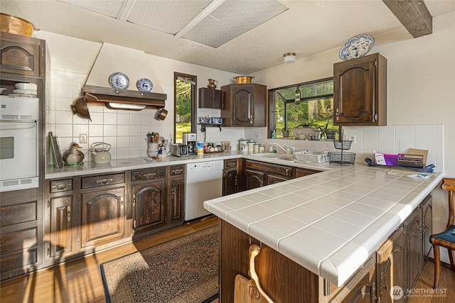 kitchen featuring white appliances, tile countertops, and tasteful backsplash