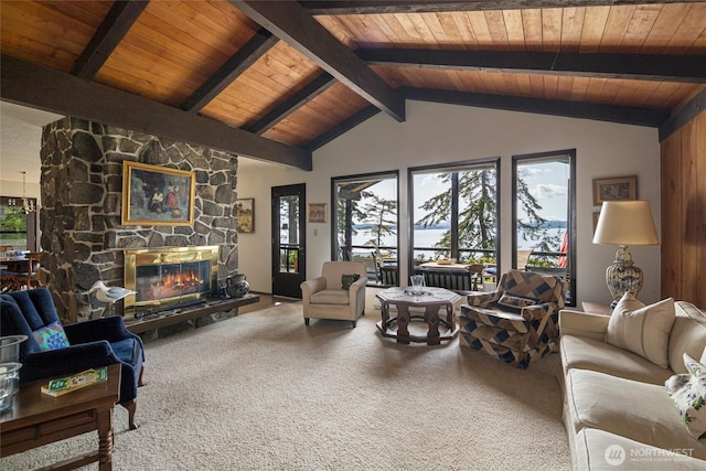 carpeted living area with lofted ceiling with beams, wood ceiling, plenty of natural light, and a fireplace