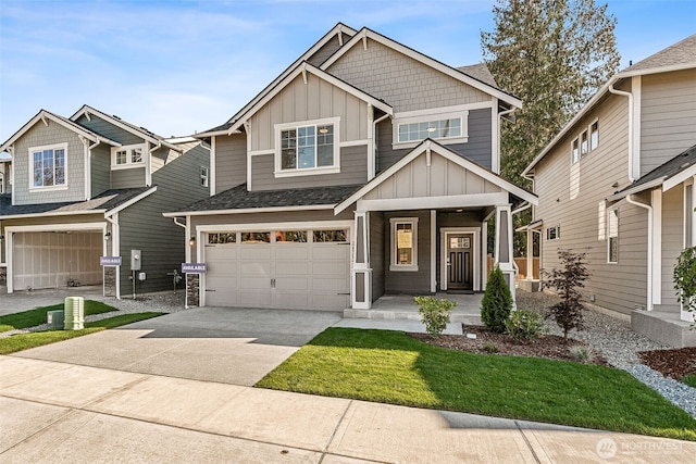 craftsman-style home with board and batten siding, covered porch, a front yard, concrete driveway, and an attached garage