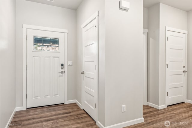 entrance foyer with baseboards and wood finished floors