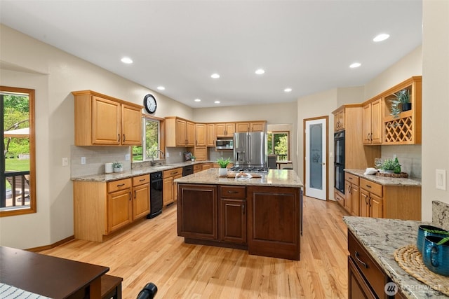 kitchen with black appliances, a sink, decorative backsplash, light wood-type flooring, and recessed lighting