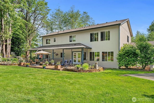 rear view of property with french doors, a patio area, and a lawn