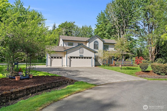traditional home featuring asphalt driveway and an attached garage
