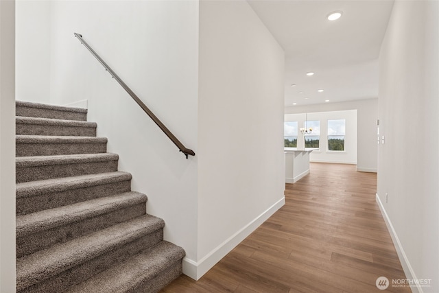 stairway featuring baseboards, recessed lighting, and wood finished floors