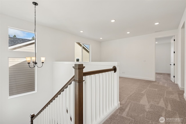 corridor with light carpet, baseboards, recessed lighting, a chandelier, and an upstairs landing