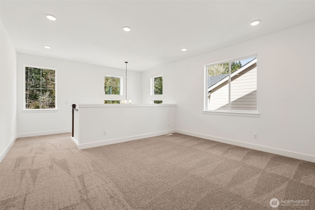 empty room featuring recessed lighting, baseboards, and light carpet