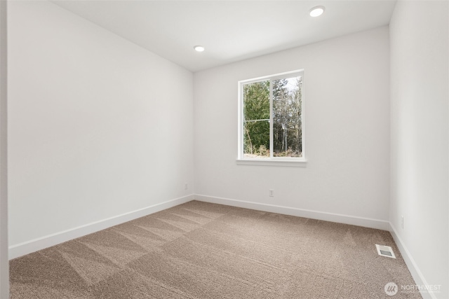 carpeted spare room with recessed lighting, baseboards, and visible vents
