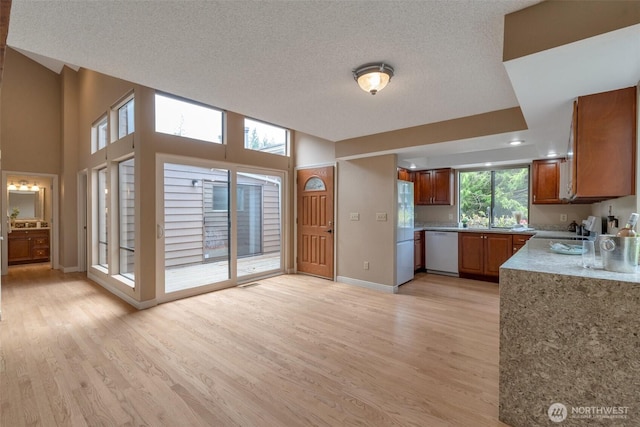 25432 213th Pl SE Unit 4, Maple Valley, WA 98038 - kitchen with white appliances, light wood-type flooring, brown cabinets, baseboards, and a textured ceiling