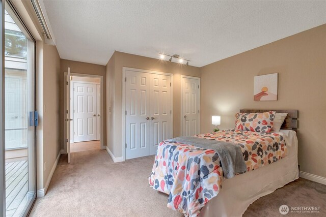 25432 213th Pl SE Unit 4, Maple Valley, WA 98038 - bedroom with carpet floors, baseboards, a closet, a textured ceiling, and rail lighting