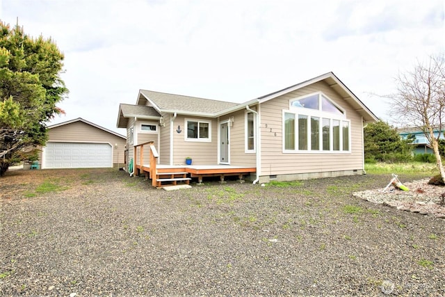 rear view of property with a wooden deck, an outbuilding, crawl space, and a detached garage