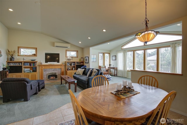 dining area with a warm lit fireplace, a wall mounted air conditioner, recessed lighting, light tile patterned floors, and vaulted ceiling