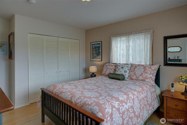 bedroom with a closet, baseboards, and wood finished floors