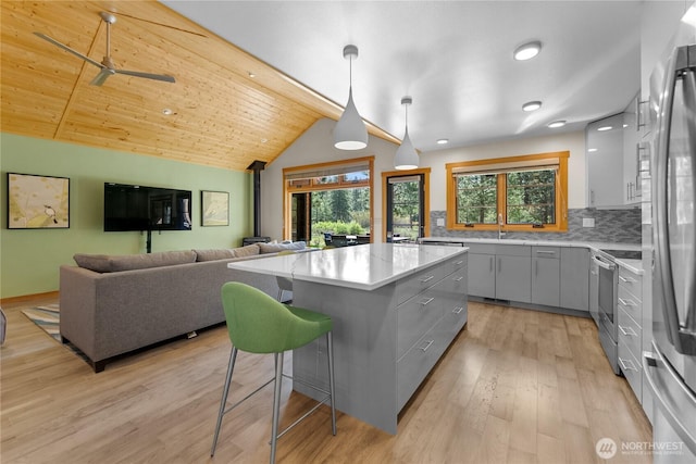 kitchen with gray cabinetry, a wealth of natural light, stainless steel appliances, and a center island