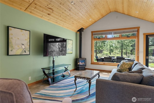 living area with wood finished floors, a wood stove, vaulted ceiling, wood ceiling, and baseboards