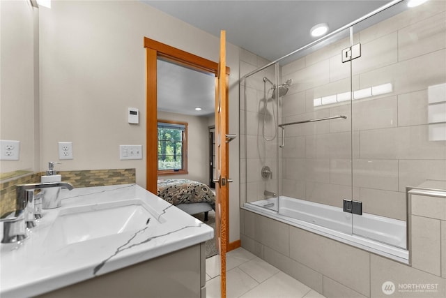 full bath featuring tiled shower / bath combo, ensuite bathroom, tile patterned flooring, and vanity