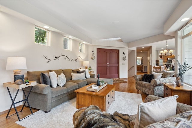 living area with light wood-style floors, a chandelier, recessed lighting, and stairway