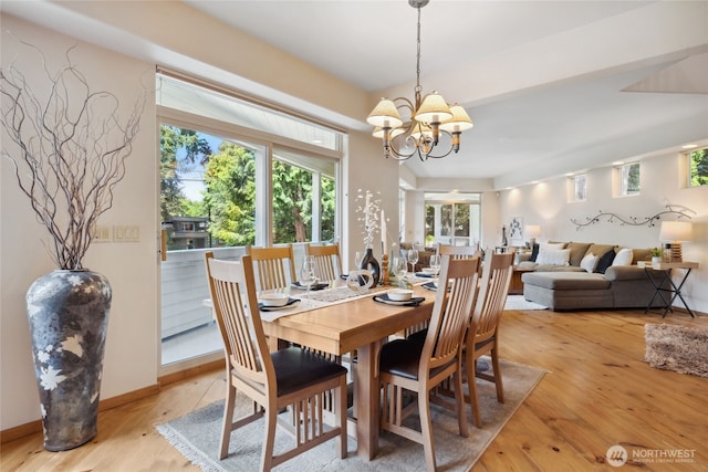dining space with light wood-style floors, a chandelier, and baseboards