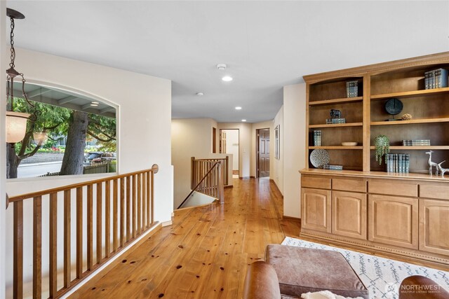 hall featuring an upstairs landing, light wood-style floors, recessed lighting, and baseboards