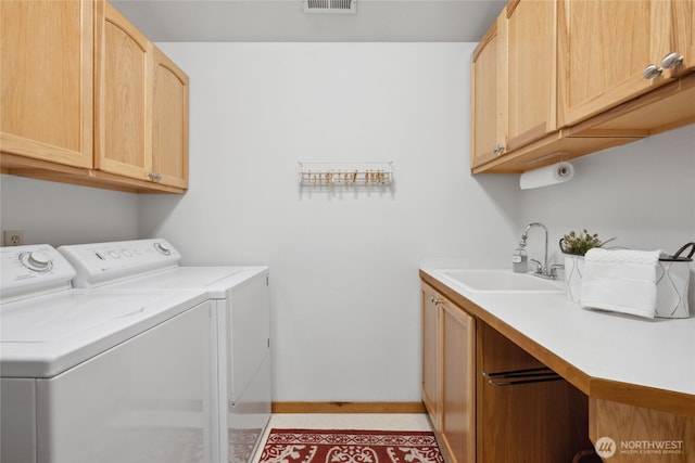 washroom with washer and dryer, cabinet space, and baseboards