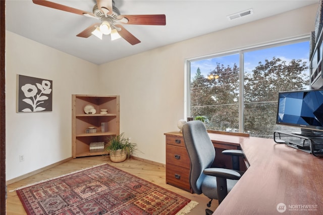 office featuring a ceiling fan, light wood-style floors, and baseboards
