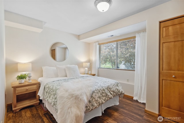 bedroom with dark wood-style flooring and baseboards