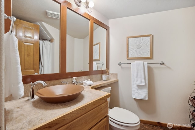 bathroom featuring vanity and toilet