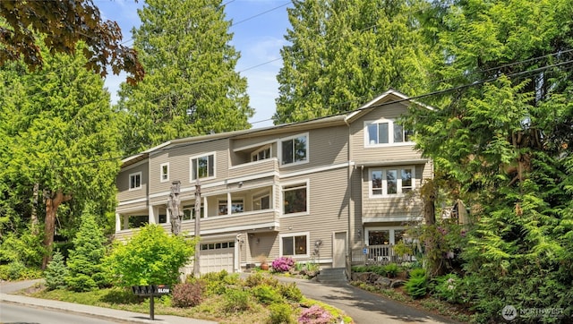 view of property with a garage and asphalt driveway