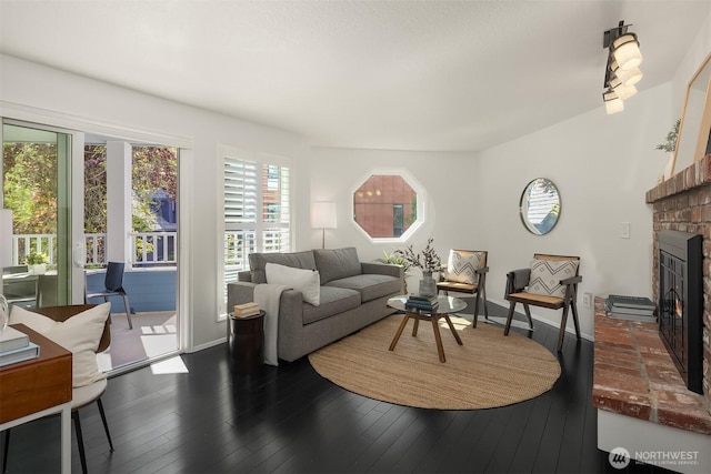 living area with a fireplace, baseboards, and wood finished floors