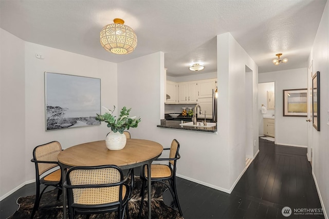 dining room featuring dark wood-style flooring and baseboards