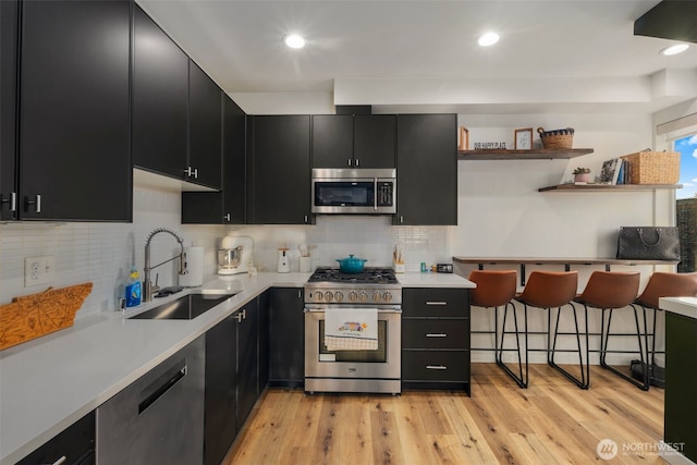 9429 18th Ave SW Unit A, Seattle, WA 98106 - kitchen featuring dark cabinets, appliances with stainless steel finishes, a sink, light countertops, and recessed lighting