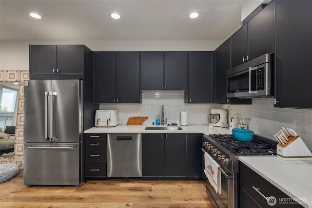 9429 18th Ave SW Unit A, Seattle, WA 98106 - kitchen featuring premium appliances, a sink, dark cabinets, and recessed lighting