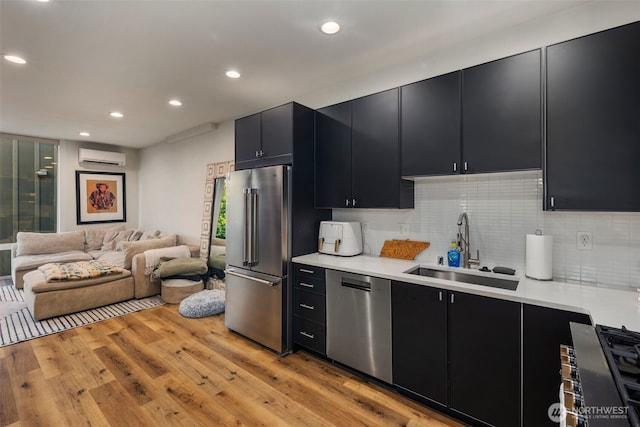 9429 18th Ave SW Unit A, Seattle, WA 98106 - kitchen featuring dark cabinetry, stainless steel appliances, a sink, recessed lighting, and light countertops
