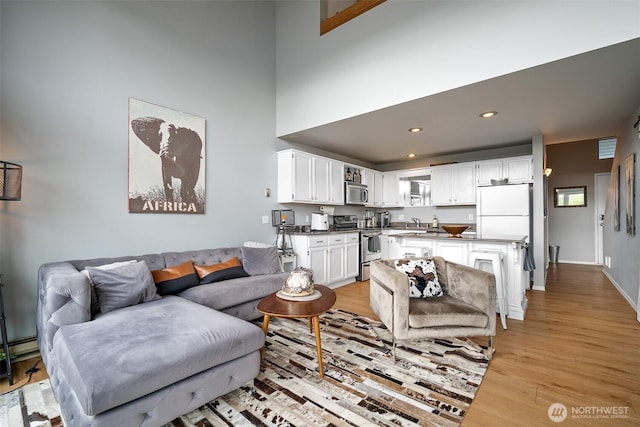 7806 Birch Bay Dr Unit 808, Blaine, WA 98230 - living room featuring light wood-type flooring, a baseboard heating unit, and recessed lighting