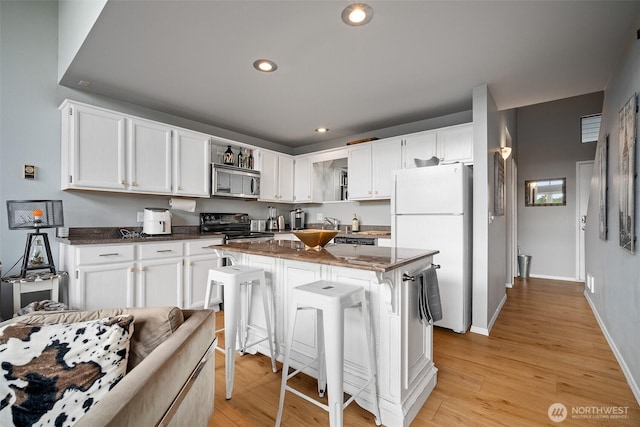 7806 Birch Bay Dr Unit 808, Blaine, WA 98230 - kitchen featuring freestanding refrigerator, stainless steel microwave, white cabinets, electric range oven, and dark stone countertops