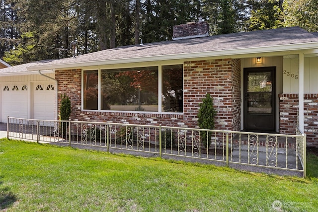 ranch-style home featuring a chimney, a front yard, a garage, brick siding, and fence