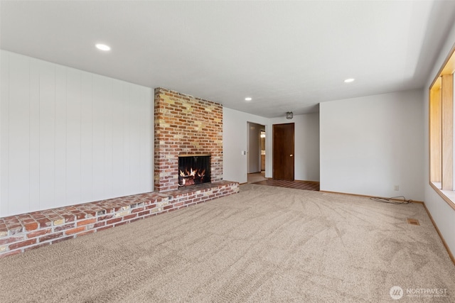 unfurnished living room featuring carpet floors, recessed lighting, and a fireplace