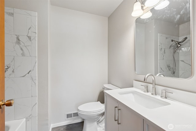 bathroom featuring vanity, toilet, baseboards, wood finished floors, and visible vents