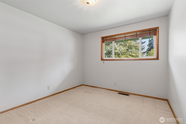 carpeted spare room with baseboards and visible vents