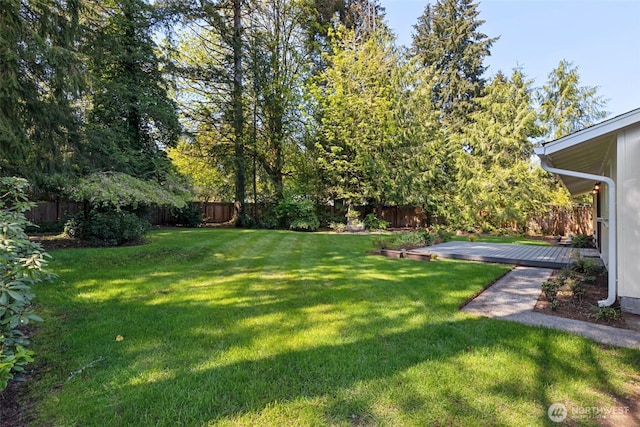 view of yard with a fenced backyard and a deck