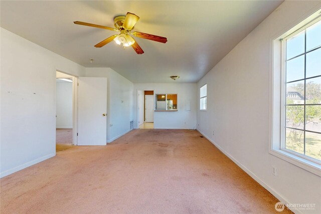 unfurnished living room featuring ceiling fan, light colored carpet, and baseboards