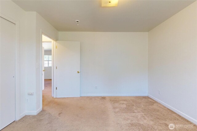 spare room featuring carpet and baseboards