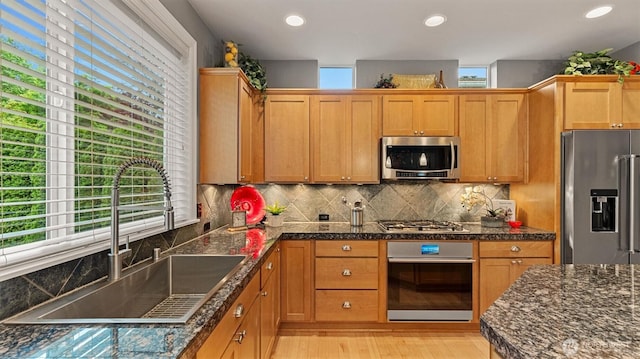 25413 NE 3rd Pl, Sammamish, WA 98074 - kitchen featuring appliances with stainless steel finishes, a sink, light wood-style floors, decorative backsplash, and recessed lighting